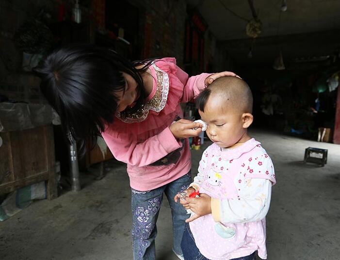 Wen Fazhi looks after her younger sister. [Xinhua]