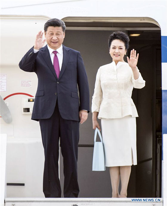 Chinese President Xi Jinping (L) and his wife Peng Liyuan wave as they arrive at the airport in Warsaw, Poland, June 19, 2016. Xi Jinping arrived in Warsaw Sunday for a state visit to Poland. [Photo/Xinhua]