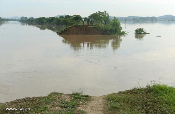 Photo taken on June 21, 2016 shows a breach on a dyke after torrential rainfall in Guxiandu Township of Poyang County, east China's Jiangxi Province. A 100-meter-wide breach was found in a dyke after a torrential rainfall, making more than 3,200 people transferred to safe place on Monday night. No casualties have been reported so far. [Photo: Xinhua]