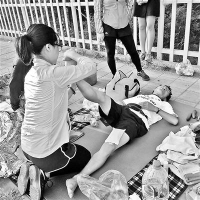 Liu Zhongjie receives emergent treatment during the long-distance jogging around Beijing's 6th Ring Road. [Photo/ Beijing Youth Daily]