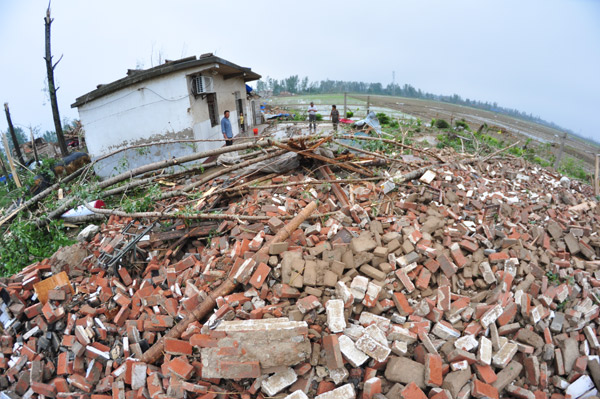  Villagers survey the rubble of a collapsed house after a tornado struck Funing in Jiangsu province on Thursday. [Photo/China Daily]