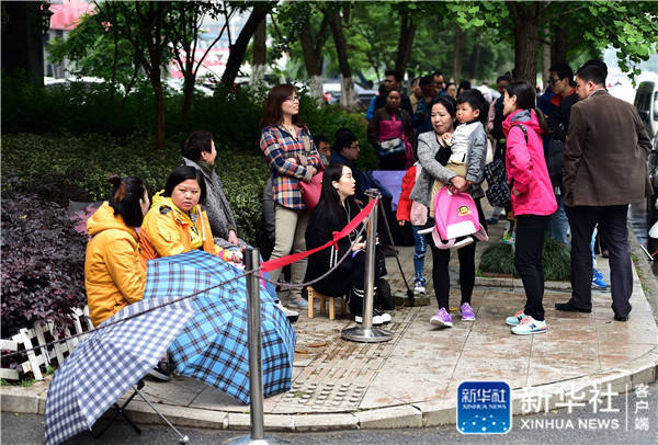 Parents stand outside a private kindergarten after queuing for more than 20 hours in Hefei City, Anhui Province on May 10. [Photo by Xinhua News Agency]