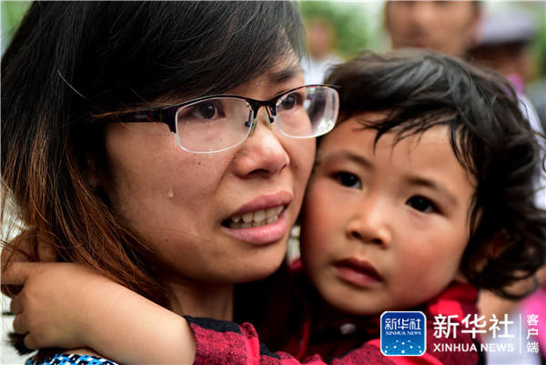 A mother sheds tears because her daughter will probably be unable to attend kindergarten after she failed the admission lottery for the Senlinhai Kindergarten in Hefei City, Anhui Province on June 8. [Photo by Xinhua News Agency] 