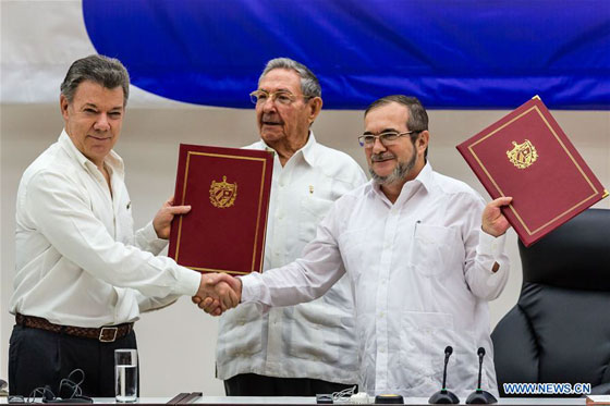 President Juan Manuel Santos (L) and Timoleon Jimenez (R), the top leader of the Revolutionary Armed Forces of Colombia (FARC), exchange pacts while Cuban President Raul Castro witnesses in Havana, capital of Cuba, June 23, 2016. [Photo/Xinhua]