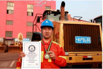 Guo Kai displays his Guinness world record certificate in front of his wheel loader. [File photo] 