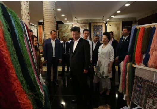 Chinese President Xi Jinping (C, front) and his wife Peng Liyuan visit a carpet and silk workshop in the old city of Bukhara as accompanied by Uzbek Prime Minister Shavkat Mirziyoev, in Bukhara, Uzbekistan, June 21. 