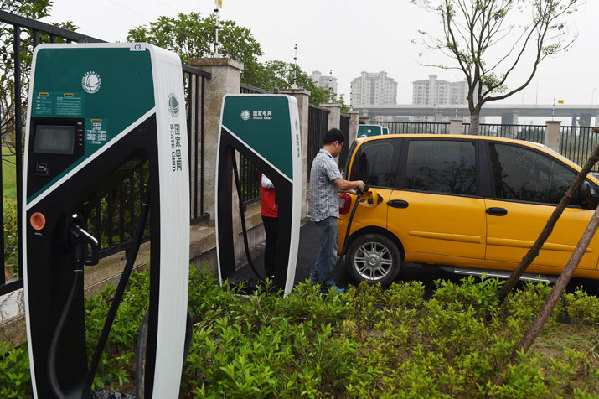 A driver has an electric car charged in Hangzhou. [By Qu Wei / Beijing Review] 