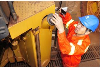 Guo Kai maintains his wheel loader.[File photo] 