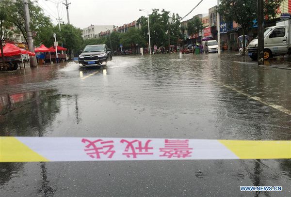 A vehicle runs on a waterlogged road in Chaohu City, east China's Anhui Province, July 2, 2016. Heavy rainfall hit the city from Friday to Saturday. [Photo/Xinhua]