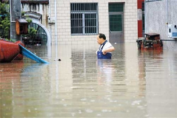 A villager wades through chest-high floodwater in Changzhou, east China's Jiangsu Province, yesterday. [Xinhua]