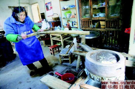 Mao Shihua grinds soybeans at her home. The 83-year-old sells affordable breakfast to students in Huangtankou Primary School in Huangtankou township in East China's Zhejiang proinve for the past 24 years. [Photo/Xinhua]
