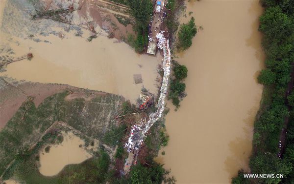 Photo taken on July 3, 2016 shows a breach at the Xinchong Village section of Shahe River in Xinzhou District of Wuhan, capital city of central China's Hubei Province. The breach caused by floods triggered by heavy rainfalls has been blocked. [Photo/Xinhua]