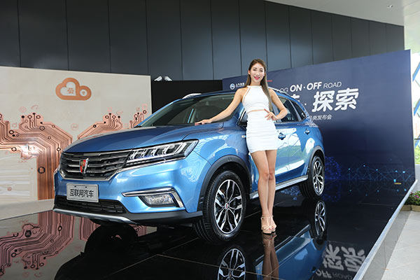 A model poses next to the OS'Car, an internet-enabled vehicle jointly developed by Alibaba and SAIC Motor Corp, on July 6, 2016 in Hangzhou, Zhejiang province . [Photo/China Daily]
