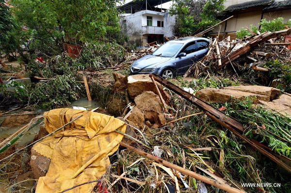 A car is buried in messes at Bandong Township after flooding in Minqing County, southeast China's Fujian Province, July 11, 2016. [Photo: Xinhua]