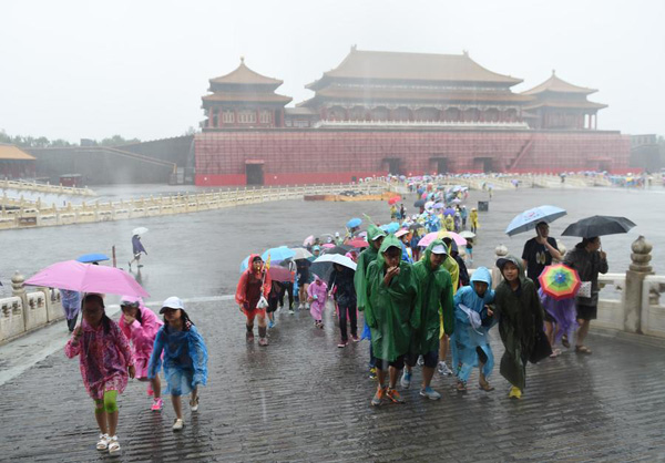 Tourists visit the Forbidden City in rain in Beijing on July 20, 2016. [Photo/Xinhua] 