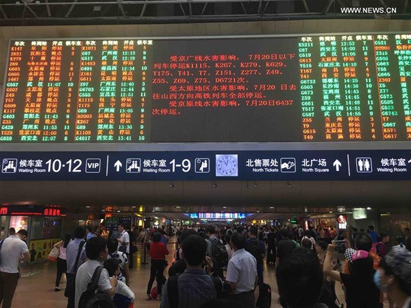 Passengers checking train information at the Beijing West Railway Station in Beijing, capital of China on July 20, 2016.The continuous rain led to delay or suspension of several trains to and from Beijing. (Photo:Xinhua/Wang Jianhua)