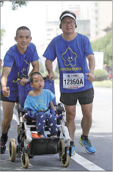 Luo Shujian (left) runs with his son Xiao Bo at a marathon event held in Lanzhou, Gansu province. [Photo/China Daily]