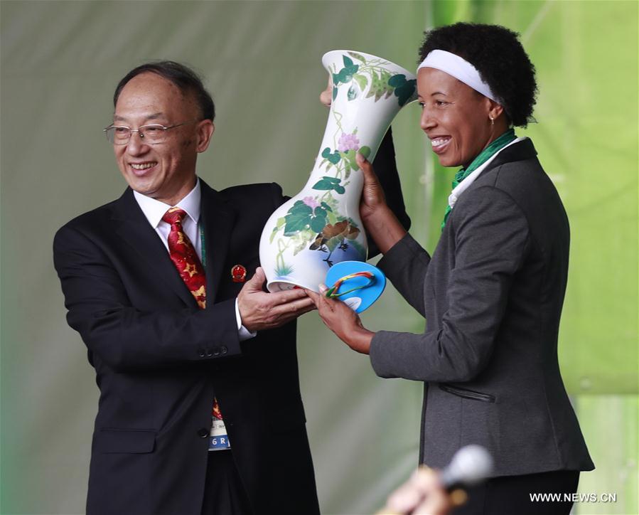 Liu Peng (L), Chef de mission of Chinese delegation and director of General Administration of Sports of China presents a gift to the Olympic Village in Rio de Janeiro, Brazil, on Aug. 3, 2016. Chinese delegation holds the flag-raising ceremony at the Olympic Village on Wednesday. (Xinhua/Ren Zhenglai) 