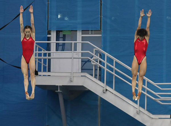 Chinese diving athletes Wu Minxia (L) and Shi Tingmao act during the final of women's SYNC.3M Springboard in Rio de Janeiro, Brazil, on Aug 7, 2016. [Photo / Xinhua]