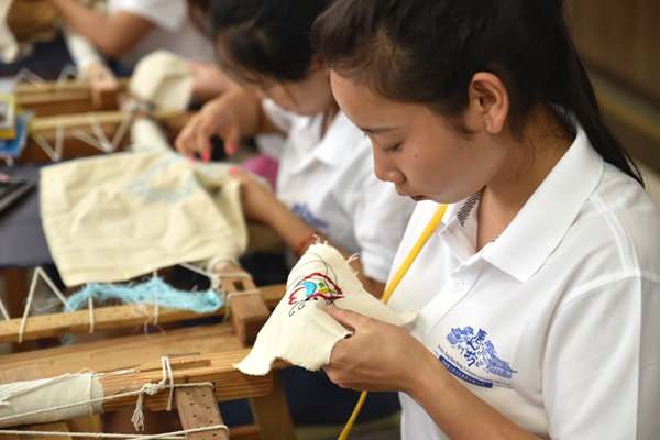 A student studies traditional embroidery in a class provided by the Minority Culture Heritage Center in Guizhou Forerunner College. [Photo by Cecile Zehnacker]