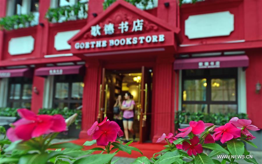People walk out of Goethe Bookstore in Shenyang, northeast China's Liaoning Province, Aug. 18, 2016. Goethe Bookstore, a 24-hour bookstore featuring books of social science, original books of German, French, and English, vinyl records, exotic gifts, art performances and reading clubs, opened Thursday in an ancient building at Zhongshan Square in Shenyang. [Xinhua]