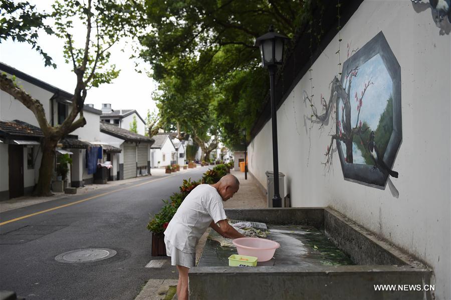 The 82-year-old Yang Dongyi washes clothes at the reconstructed Mantoushan Community in Hangzhou, capital of east China's Zhejiang Province, Aug. 22, 2016. Hangzhou has been massively upgrading the city's infrastructure with such improvements as repaving roads, expanding its subway system and dredging waterway for the G20 summit over the last couple of years. [Photo/Xinhua]