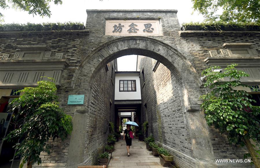 A resident walks past ancient architectural complex at Sixinfang in Hangzhou, capital of east China's Zhejiang Province, Aug. 22, 2016. Hangzhou has been massively upgrading the city's infrastructure with such improvements as repaving roads, expanding its subway system and dredging waterway for the G20 summit over the last couple of years. [Photo/Xinhua]