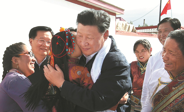 President Xi Jinping hugs 5-year-old Tseyang Lhamo while visiting Tibetan ethnic villagers in Qinghai province onMonday. [Photo/Xinhua]