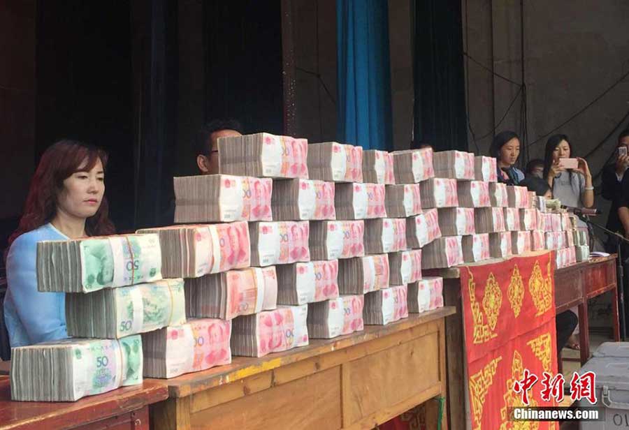 About 5.6 million yuan (850,000 US dollars) was distributed on Saturday to 80 households who took part in a tree planting scheme in a village in Lintao county, Northwest China's Gansu province. [Photo/Chinanews.com] 
