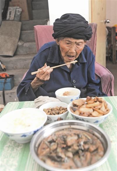 Fu Suqing eats double - fried pork at her home in Chengdu of southwestern China's Sichuan province in this undated photo. [Photo: Chengdu Business Daily]