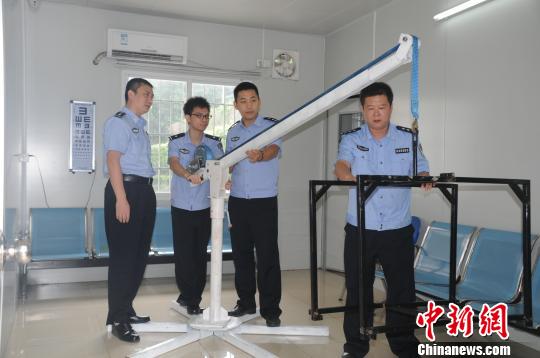 Bai Yunzhi (L1) and other policemen demonstrate how to use the device. [Photo/Chinanews.com]