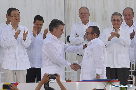 Image provided by the Colombian Presidency shows Colombian President Juan Manuel Santos (L Front) shaking hands with Commander in Chief of the Revolutionary Armed Forces of Colombia (FARC) Timoleon Jimenez during the signing ceremony of the final peace agreement between the Colombian government and FARC, in Cartagena, Colombia, Sept. 26, 2016. [Photo/Xinhua]
