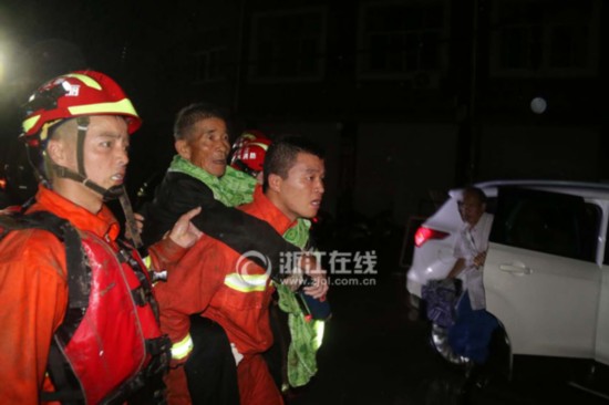 Firefighters and police evacuate residents stranded in a village in the eastern province of Zhejiang on September 28, 2016.