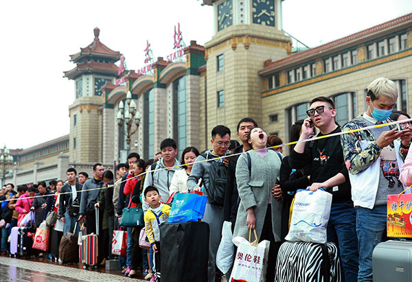 People line up to enter the subway station outside the Beijing Railway Station on Friday, the last day of the seven-day National Day holiday, after their return from traveling or visiting home during the vacation. [Photo by Zou Hong/China Daily]