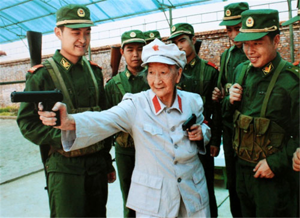 Wang Quanyuan demonstrates pistol use to young soldiers. She participated in the Red Army's Long March in October 1934 and was named the commander of a female regiment. [File photo from cpcnews.cn]