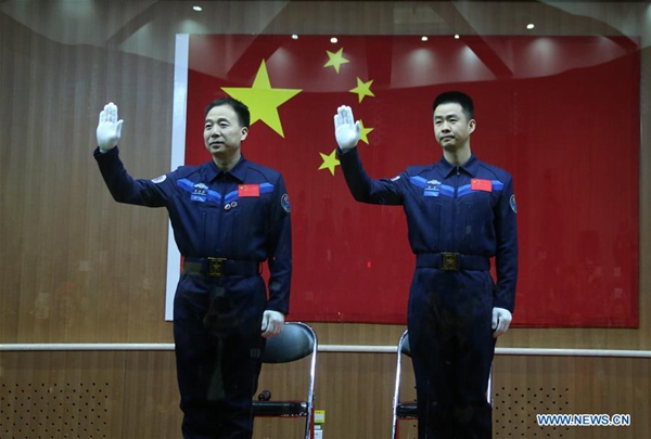Chinese astronauts Jing Haipeng (L) and Chen Dong meet the media at a press conference at the Jiuquan Satellite Launch Center in northwest China, Oct. 16, 2016. The two male astronauts will carry out the Shenzhou 11 mission. The Shenzhou 11 manned spacecraft will be launched at 7:30 a.m. Oct. 17, 2016 Beijing Time (2330 GMT Oct. 16). [Photo/Xinhua]