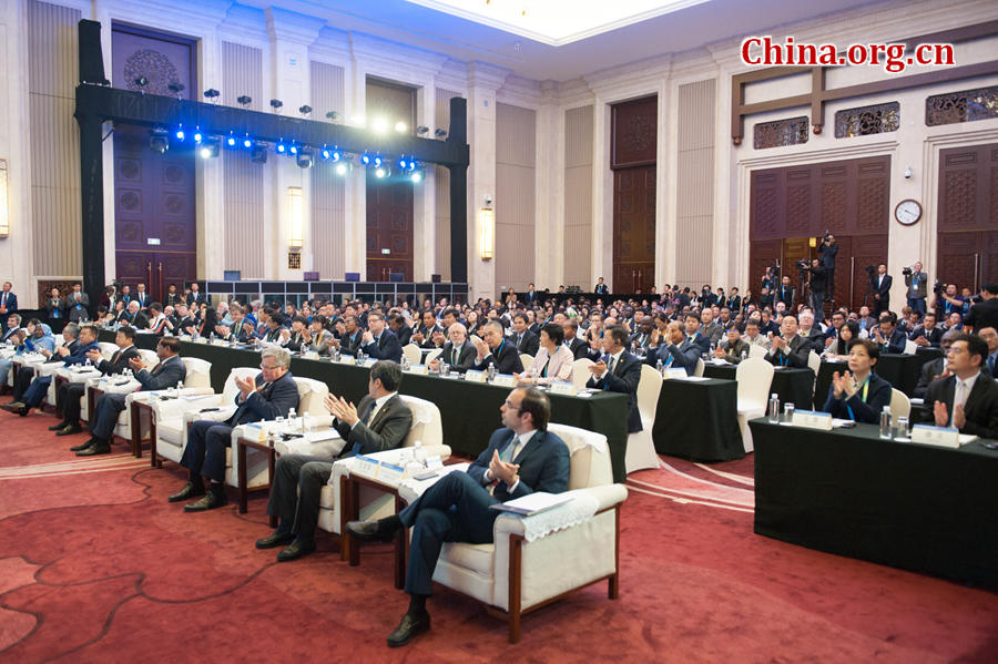 Delegates to the CPC in Dialogue with the World 2016 applause to celebrate the approval of the Chongqing Initiative at the closing ceremony of the CPC in Dialogue with the World 2016 held in southwest China's Chongqing Municipality on Oct. 15, 2016. [Photo by Chen Boyuan / China.org.cn]
