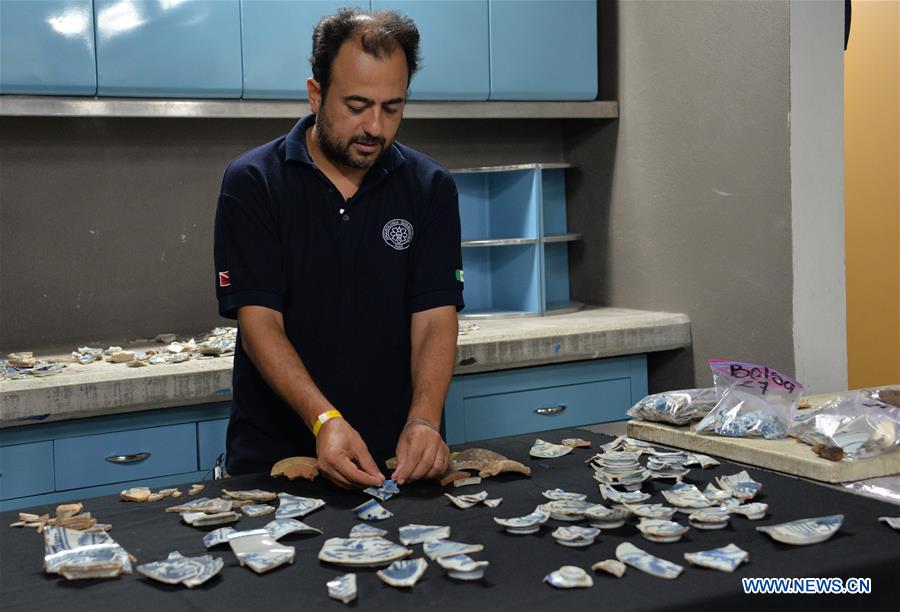 Photo taken on Oct. 7, 2016, shows an archaeologist working on antique Chinese porcelain fragments in the city of Acapulco, Mexico. A new archaeological find announced on Friday in Mexico attests to China's age-old vocation as an exporting powerhouse. Mexican archaeologists have uncovered thousands of fragments of a 400-year-old shipment of Chinese 'export-quality porcelain' that was long buried in the Pacific Coast port of Acapulco. [Photo/Xinhua] 