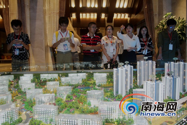 文昌高龙湾1号的工作人员向网媒记者介绍该地产楼盘项目。 [南海网 陈望 摄]