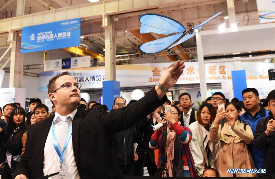 A man flies a bionic butterfly at the 2016 World Robot Exhibition in Beijing, capital of China, Oct. 21, 2016. The exhibition is held from Oct. 21 to 25 as part of the World Robot Conference. (Xinhua/Li Wen) 