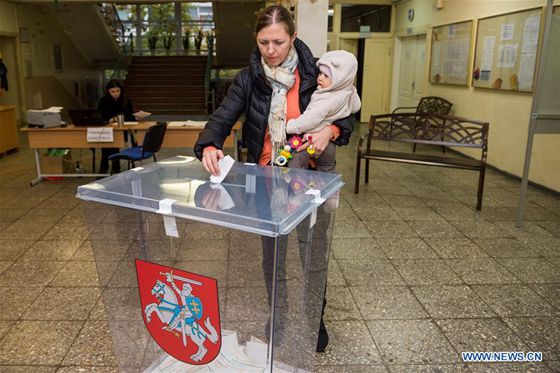 A voter casts her ballot in a polling station for the parliament election in Vilnius, Lithuania, Oct. 23, 2016. [Photo/Xinhua]