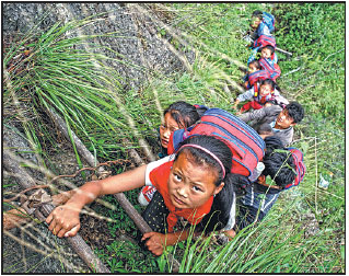 Schoolchildren use a rattan ladder in May to scale the 800-meter cliff to reach home. The children, who attend a boarding school, make the climb to and from their homes every two weeks.Chen Jie / For China Daily