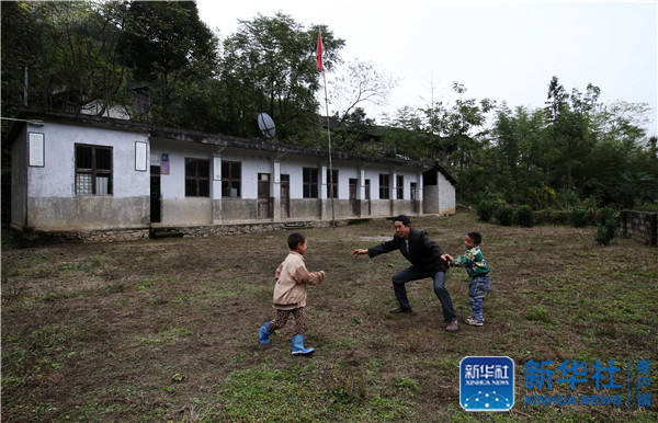 Yang Jinhua, the only teacher in Muqiao primary school, plays games with students on October 24, 2016. [Photo: Xinhua]