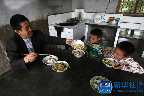 Yang Jinhua, the only teacher in Muqiao primary school, has lunch with students on October 24, 2016. [Photo: Xinhua] 