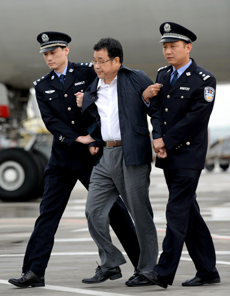 Police officers escort Li Huabo, a former finance official from Jiangxi province, at Beijing Capital International Airport after he was repatriated from Singapore in May last year. The 54-year-old fled China in 2011 after being accused of embezzling 94 million yuan ($13 million). [Photo/Xinhua]