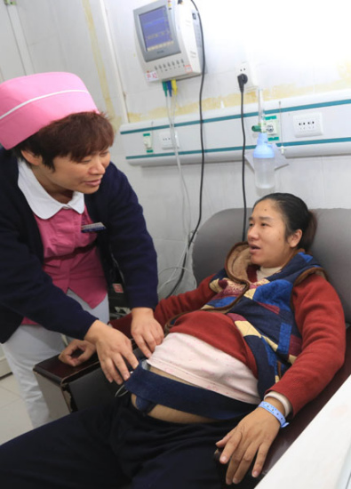 A nurse checks a pregnant woman at a hospital in Xiangyang, Hubei province, on Saturday.[Photo/China Daily]