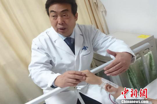 Doctor Guo Shuzhong inspected the patient after he carried out the pioneering precedure [Photo: Chinanews.com] 