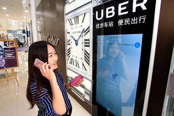 A woman uses Uber Technologies Inc's car-hailing service via an electronic screen in Tianjin.[Provided to China Daily]