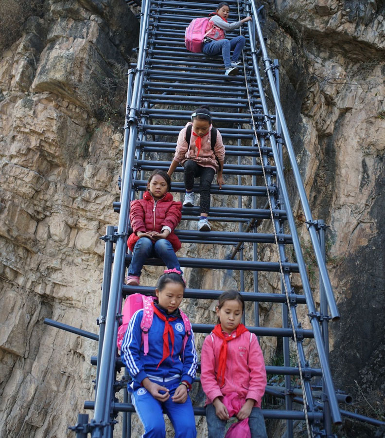 Children rest during their climb up to the cliff village in Sichuan province on Saturday, November 19, 2016. [Photo: The Beijing News] 
