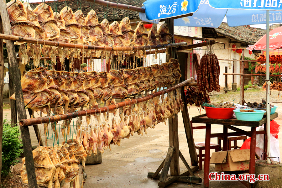 Local people sell home-made salted chickens and sausages to make a living. Nowadays, more than 300 families still live here. [Photo by Li Huiru / China.org.cn]